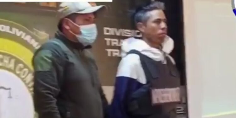Un elemento de la Policía traslada al presunto autor del doble crimen. Foto: Captura BTV