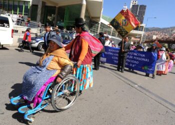 Una mujer con discapacidad se transporta por la calle.
