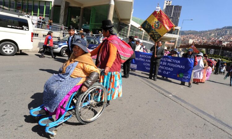 Una mujer con discapacidad se transporta por la calle.