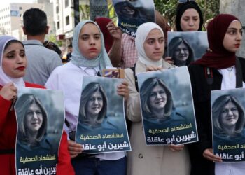 Palestinas sostienen carteles en los que aparece la veterana periodista de 'Al-Jazeera' Shireen Abu Akleh, en la ciudad cisjordana de Hebró. Foto: AFP.