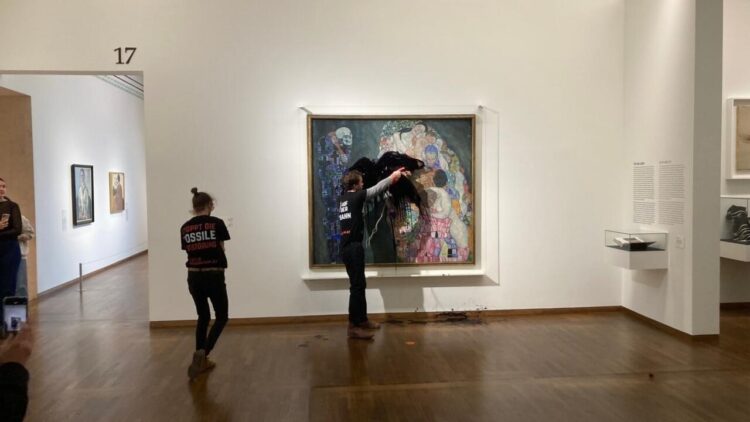 Imagen difundida por el grupo Última Generación del instante en que un activista arroja líquido negro sobre el cuadro 'Muerte y vida', de Gustav Klimt, el 15 de noviembre de 2022 en el museo Leopold de Viena. Foto: AFP.