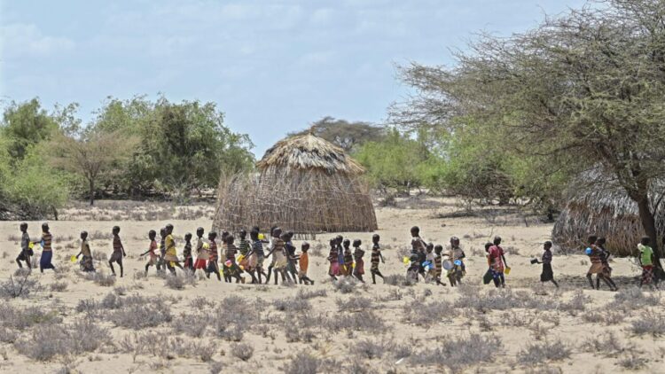 Unos niños de la comunidad turkana hacen fila para recibir comida de UNICEF en un punto de distribución en Nadoto, Kenia, el 18 de octubre de 2022. Foto: AFP.