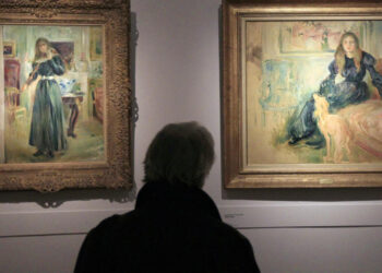Una persona contempla los cuadros 'Julie tocando el violín' (izq.) y 'Julie Manet y su lebrel Laërte', expuestos en una retrospectiva dedicada a la pintora impresionista Berthe Morisot, en el Museo Marmottan-Monet de París. Foto: AFP.