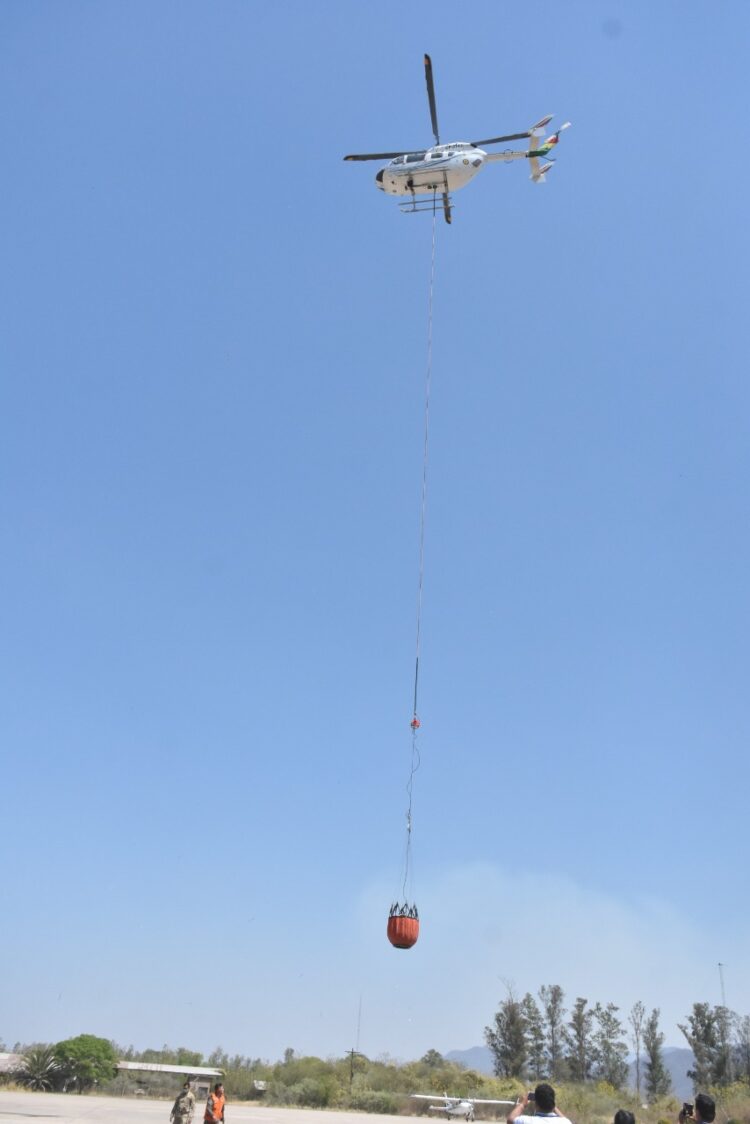 Un helicóptero llega con agua para sofocar los incendios. Foto: Defensa Civil