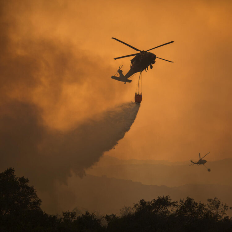 Helicópteros de la Guardia Nacional combaten un incendio forestal en California, como muestra del aumento de conflictos por el cambio climático. Foto: AFP.