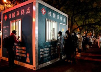 Decenas de personas guardan cola ante un punto de reparto de pruebas de detección del COVID-19, el 15 de noviembre, en Pekín. Foto: AFP.
