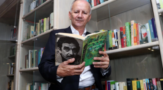 El coleccionista colombiano Jorge Salazar sostiene una edición en inglés de la obra 'Cien años de soledad', de Gabriel García Márquez. Foto: AFP.