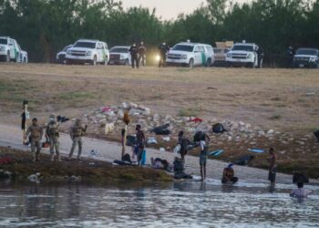 Migrantes haitianos cruzan el Río Grande hacia Estados Unidos bajo la vigilancia de la policía fronteriza estadounidense en Ciudad Acuna (México) el 23 de septiembre de 2021. Foto: AFP.