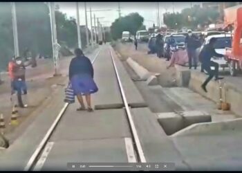 Un hombre y una mujer saltan de la vía del Tren Metropolitano. Foto: Captura