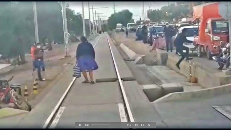 Un hombre y una mujer saltan de la vía del Tren Metropolitano. Foto: Captura