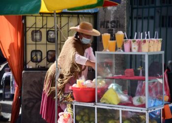 Una mujer comerciante ofrece sus jugos. Foto: Archivo