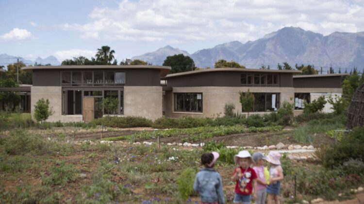 Unas niñas caminan por las instalaciones de la "escuela verde" de Paarl, a unos 60 kilómetros de Ciudad del Cabo, el 7 de noviembre de 2022. Foto: AFP.