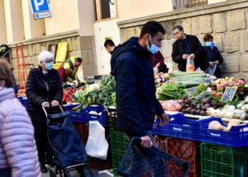 Varias personas compran en un mercado callejero del pueblo catalán de Guissona, cerca de Lérida, en un ejemplo del alza de costos de alimentos en España. Foto: AFP.