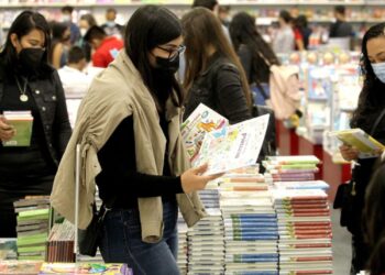 Personas ojean libros durante el tercer día de la Feria Internacional del Libro de Guadalajara, en Guadalajara, México, el 29 de noviembre de 2021. Foto: AFP.