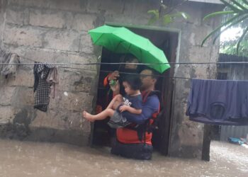 Un rescatista ayuda a evacuar a una niña en la ciudad filipina de Ozamiz, el 25 de diciembre de 2022. Foto: AFP.