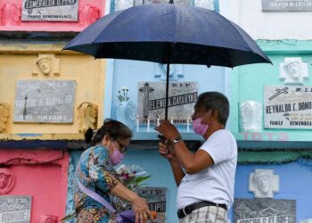 Una pareja de filipinos enciende velas por el Día de Todos los Santos en el Cementerio Manila Norte de la capital de Filipinas, el 1 de noviembre de 2022. Foto: AFP.