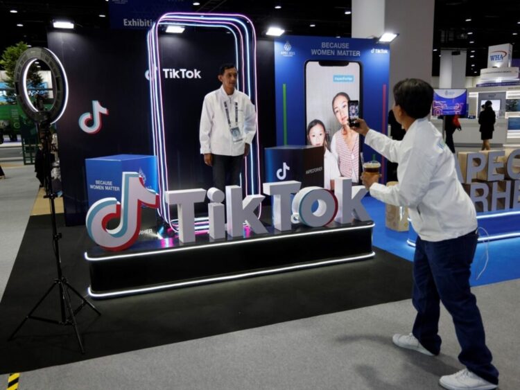 Un hombre posa en el stand de TikTok en el centro internacional de medios durante la cumbre de Cooperación Económica Asia-Pacífico (APEC) en Bangkok el 18 de noviembre de 2022. Foto: AFP.