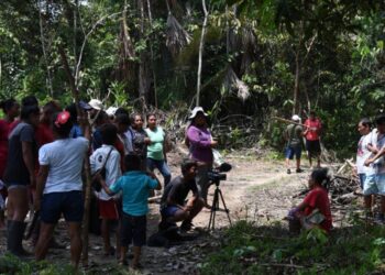 Miembros del pueblo indígena Tikuna filman, con el apoyo de los Matis, una película el 14 de octubre de 2022 en San Martín de Amacayacu, en la selva amazónica colombiana. Foto: AFP.