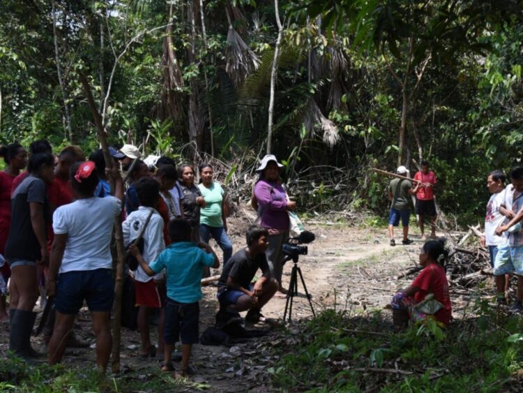 Miembros del pueblo indígena Tikuna filman, con el apoyo de los Matis, una película el 14 de octubre de 2022 en San Martín de Amacayacu, en la selva amazónica colombiana. Foto: AFP.