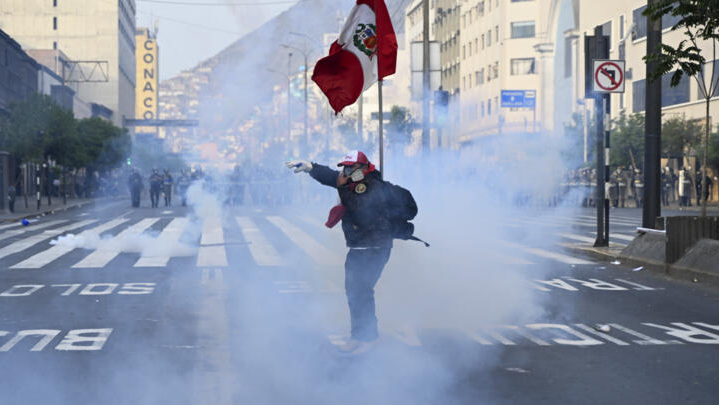 Un simpatizante del expresidente peruano Pedro Castillo lleva una máscara para protegerse de los gases lacrimógenos en una protesta cerca del Congreso peruano en Lima, el 12 de diciembre de 2022. Foto: AFP.