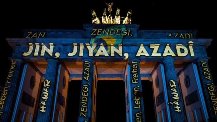 La Puerta de Brandeburgo de Berlín (Alemania) iluminada en apoyo a los manifestantes en Irán, con el lema "Mujer, vida, libertad", el 13 de diciembre de 2022. Foto: AFP.