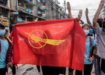 Unos manifestantes sostienen la bandera del Sindicato de Estudiantes de Birmania durante una protesta contra el golpe militar, el 13 de junio de 2021 en Rangún. Foto: AFP.