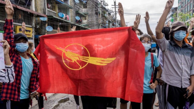 Unos manifestantes sostienen la bandera del Sindicato de Estudiantes de Birmania durante una protesta contra el golpe militar, el 13 de junio de 2021 en Rangún. Foto: AFP.