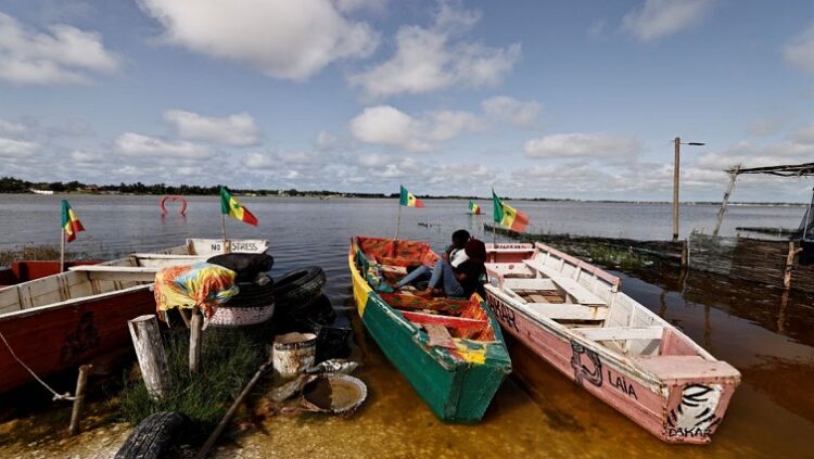 Después de días de lluvias torrenciales, el minero de sal Moussa Diare solo pudo ver con desesperación cómo las aguas de la inundación abrían una brecha de un metro de ancho en las orillas del Lago Rosa de Senegal y arrastraba miles de dólares en montículos de sal que había reunido. Foto: AFP.