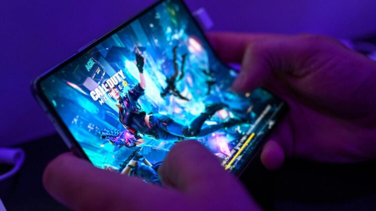 Una persona juega al videojuego 'Call of Duty' en un teléfono móvil el 24 de agosto de 2022 en la feria Gamescom de Colonia, Alemania. Foto: AFP.
