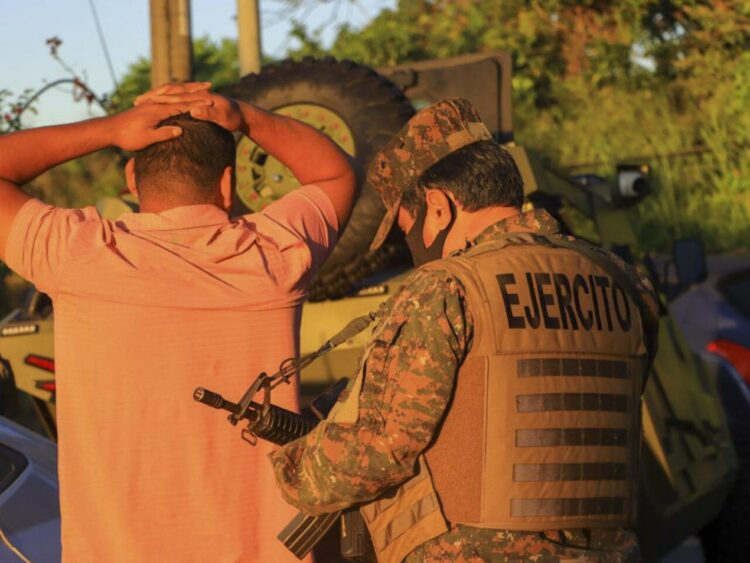 Un soldado cachea a un hombre durante una operación de búsqueda de pandilleros en el municipio de Soyapango, El Salvador, el 3 de diciembre de 2022. Foto: AFP.