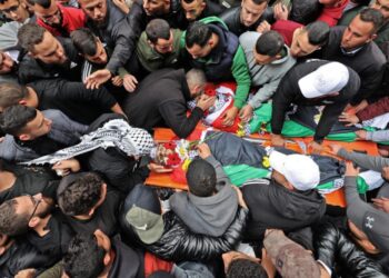 Una multitud rodea los cadáveres de dos palestinos muertos en enfrentamientos con las fuerzas israelíes, el 29 de noviembre de 2022 en la ciudad cisjordana de Ramala. Foto: AFP.