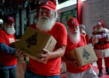 Un grupo de Papás Noel reciben una cesta de Navidad en Rio de Janeiro, el 20 de diciembre de 2022. Foto: AFP.