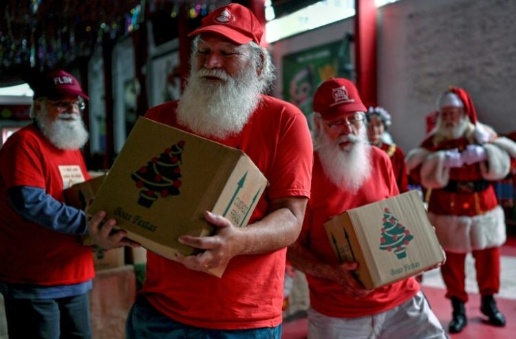 Un grupo de Papás Noel reciben una cesta de Navidad en Rio de Janeiro, el 20 de diciembre de 2022. Foto: AFP.