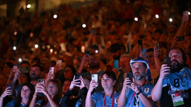 Aficionados de Uruguay usan su teléfono celular en el estadio de Lusail antes del partido contra Portugal del grupo H del Mundial de Catar, el 28 de noviembre de 2022 en al norte de Doha. Foto: AFP.