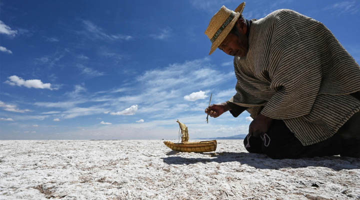 Félix Mauricio, de la comunidad indígena Uru Murato, con una réplica de balsa de totora, una embarcación tradicional de la región, donde antes estaba el lago Poopó, cerca de Puñaca Tinta María, provincia de Oruro, Bolivia. Foto: AFP.