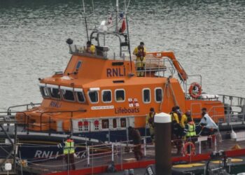 Migrantes rescatados en el mar cuando trataban de cruzar el canal de la Mancha desembarcan de un navío de rescate martítimo británico, el 14 de diciembre de 2022 en el puerto de Dover, al sur de Inglaterra. Foto: AFP.