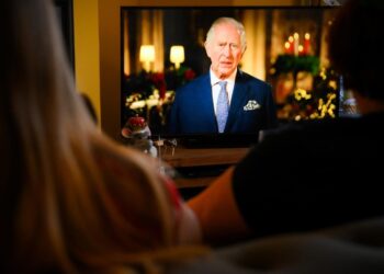 Una familia mira el discurso navideño del rey Carlos III, en Liverpool, Reino Unido, el 25 de diciembre de 2022. Foto: AFP.