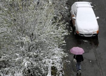 Una mujer camina en la ciudad ucraniana de Leópolis, tras caer la primera nevada en el terrotorio ucraniano. Foto: AFP.