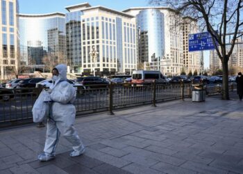 Una mujer vestida con un equipo de proteción sanitaria en una calle de Pekín, China, el 26 de enero de 2022. Foto: AFP.