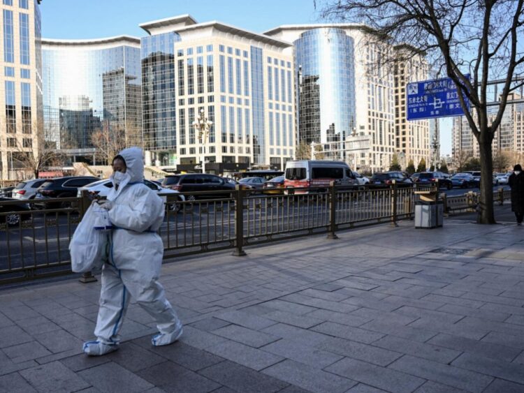 Una mujer vestida con un equipo de proteción sanitaria en una calle de Pekín, China, el 26 de enero de 2022. Foto: AFP.