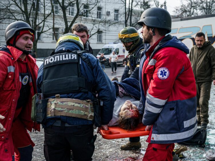 Miembros del Servicio de emergencia trasladan a una mujer herida tras un bombardeo ruso en el centro de la ciudad ucraniana de Jersón, el 24 de diciembre de 2022. Foto: AFP,