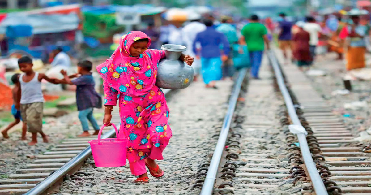Una mujer carga agua potable para su consumo en Dhaka, Bangladesh.