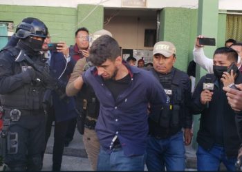 El reo recapturado es llevado bajo fuerte resguardo policial. Foto: Roberto Guzmán.