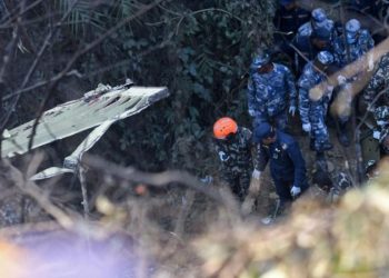 Rescatistas colaboran con los cuerpos de los fallecidos del accidente de avión en Nepal. Foto: AFP.
