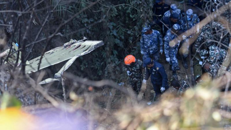 Rescatistas colaboran con los cuerpos de los fallecidos del accidente de avión en Nepal. Foto: AFP.
