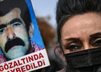 La activista turca de los derechos humanos Eren Keskin sostiene una imagen de un hombre desaparecido, el 25 de marzo de 2021 frente a un tribunal de Estambul, antes de un juicio. Foto: AFP.