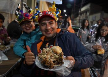 Un comensal degusta el rostro asado orureño, famoso plato de cabeza de cordero. Foto: AFP