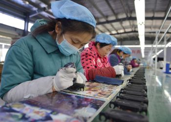 Mujeres trabajan en la línea de ensamblaje de una fábrica de parlantes en la ciudad de Fuyang, este de China, el 30 de noviembre de 2022. Foto: AFP.
