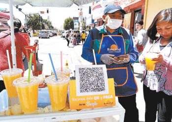 Un vendedor de refresco ofrece el pago del QR para su producto.