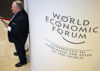 Un participante del Foro Económico Mundial usa su teléfono móvil en el centro de congresos en Davos, Suiza, el 18 de enero de 2023. Foto: AFP.